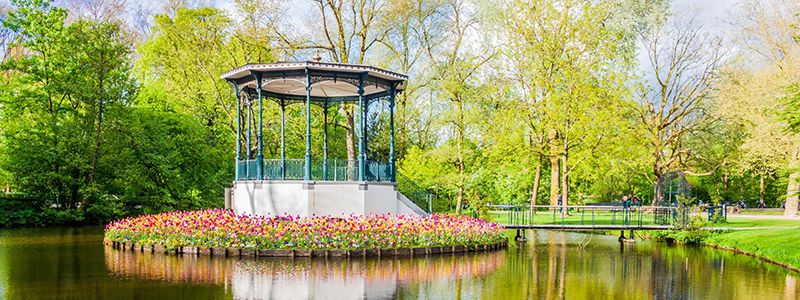 Litet hus vid sjn kring blommor i Vondelpark, Holland.